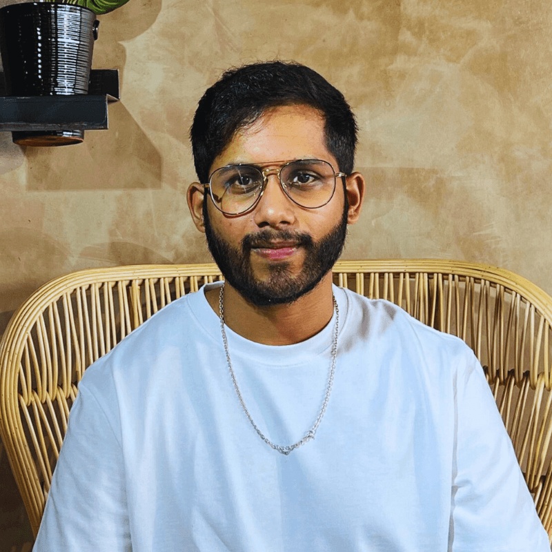 Akhil Boddu, AfricanTechBro, smiling in his glasses and white T-shirt