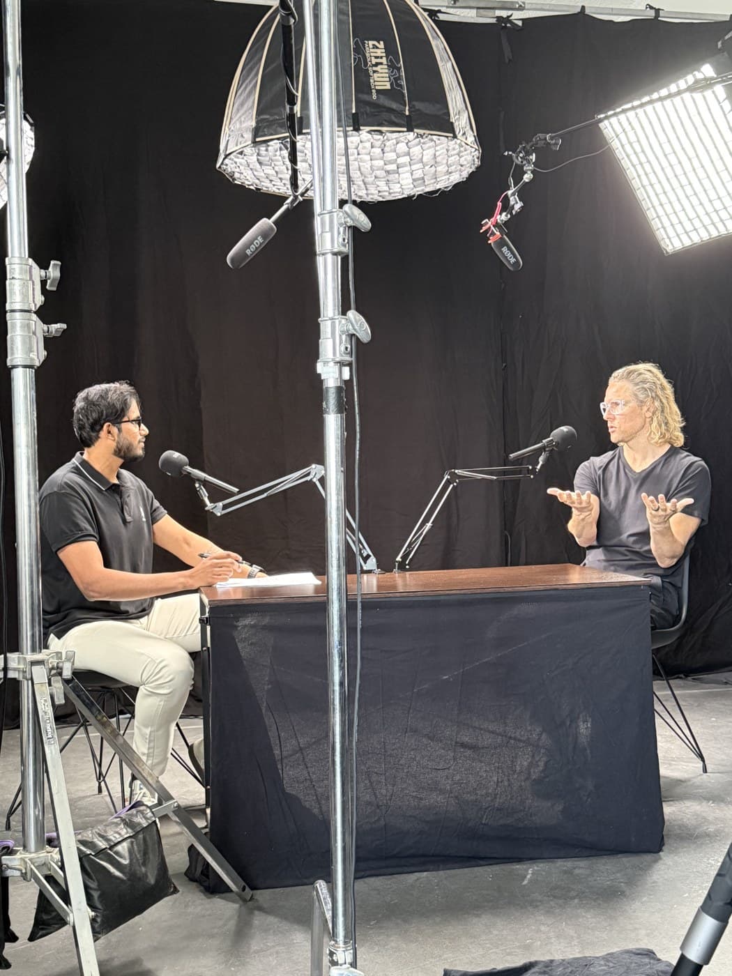 Akhil and Johan Wiggins in conversation at the desk, recording Episode 01 at De Boov Studios